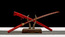Handmade high-quality T10 steel katana with red pattern, displayed on wooden stand.